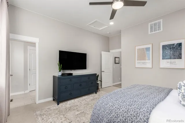 a spacious bedroom with a bed and a flat screen tv
