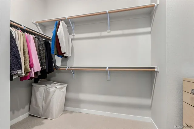 a view of walk in closet with clothes and shoes