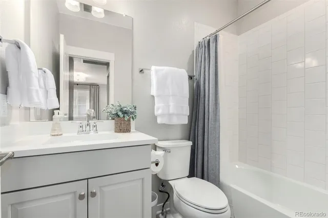 a bathroom with a sink a toilet a mirror and shower