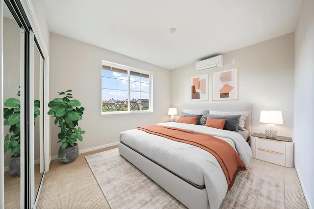 a bedroom with a large bed and a potted plant