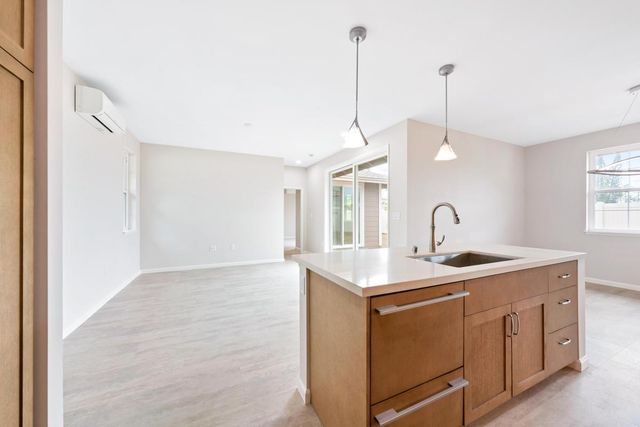 a view of a kitchen with a sink a window and appliances