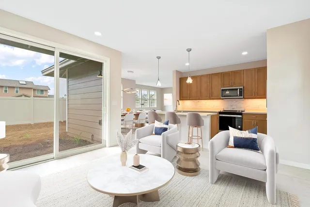 a living room with furniture a fireplace and kitchen view