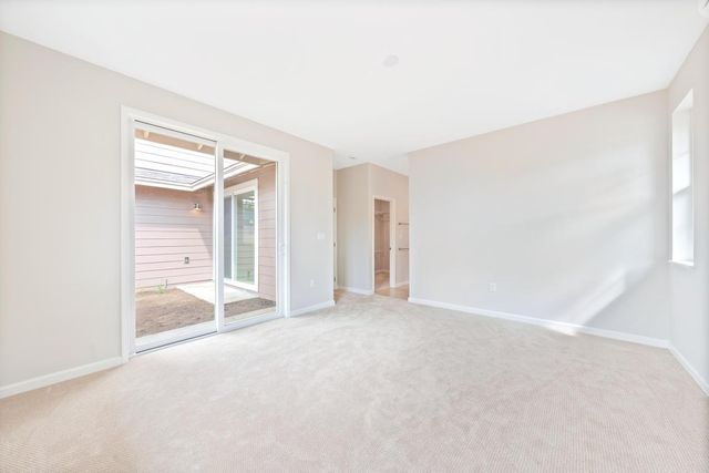 an empty room with an entryway and windows