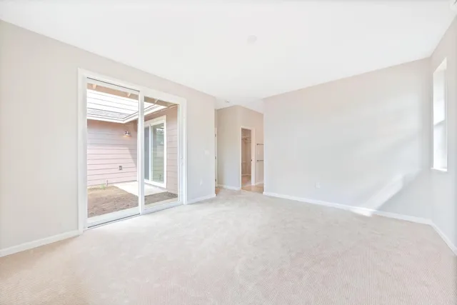 an empty room with an entryway and windows