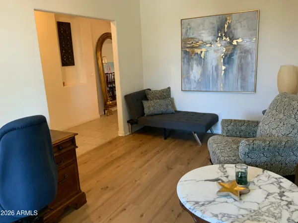 a living room with furniture and a wooden floor