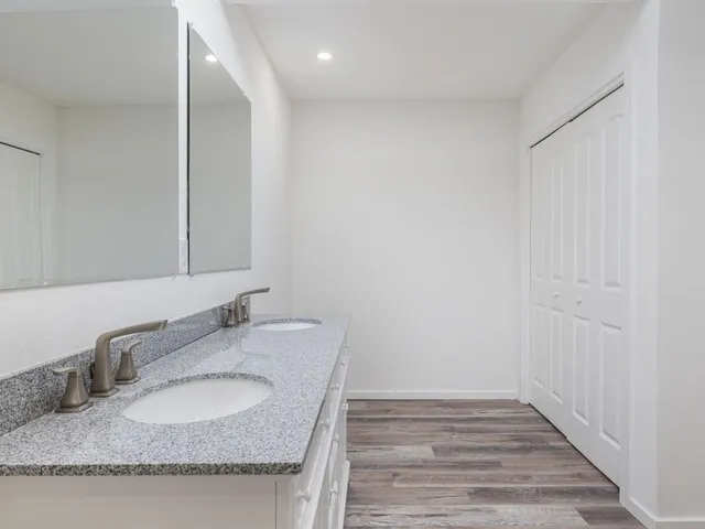 a bathroom with a granite countertop sink and a mirror