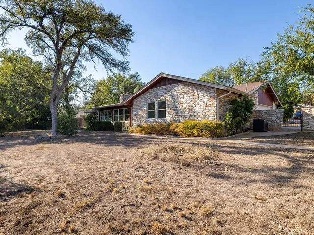a view of a house with backyard and trees
