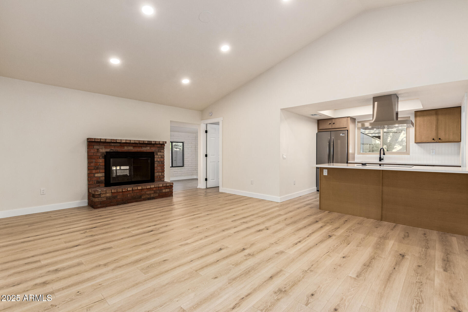 1514 West Loughlin Drive Chandler, AZ 85224 - Photo 11 of 33 a view of kitchen with kitchen island a sink wooden floor and a fireplace