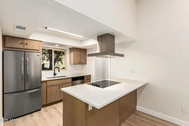 a kitchen with stainless steel appliances a sink and refrigerator