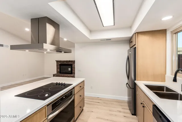 a kitchen with stainless steel appliances granite countertop a stove a sink and a refrigerator