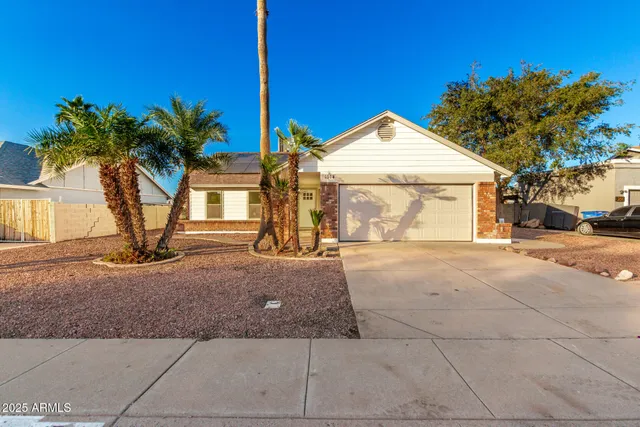 a view of a house with a yard and potted plants