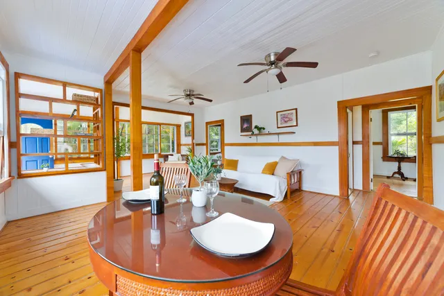 a dining room with wooden floor and a chandelier