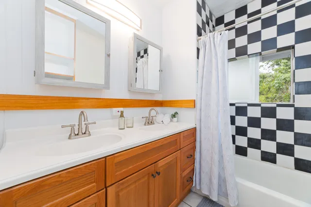 a bathroom with a sink a large mirror and a bathtub