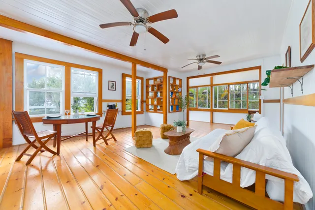 a view of a dining room with furniture a chandelier and wooden floor