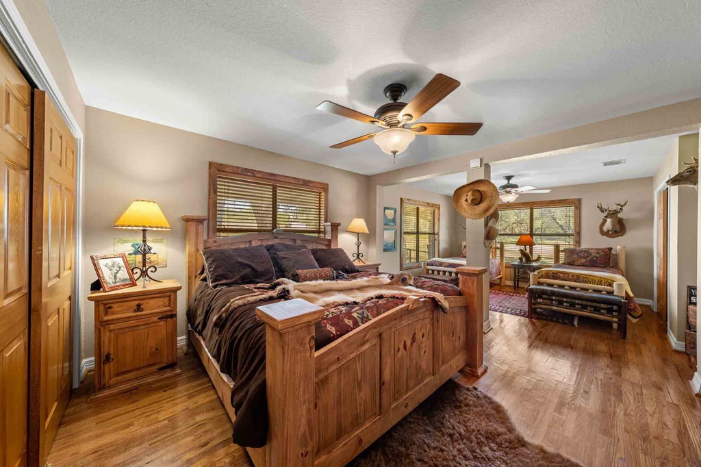 161 Flach Rnch Road Comfort, TX 78013 - Photo 40 of 69 a bedroom with a bed and a chandelier