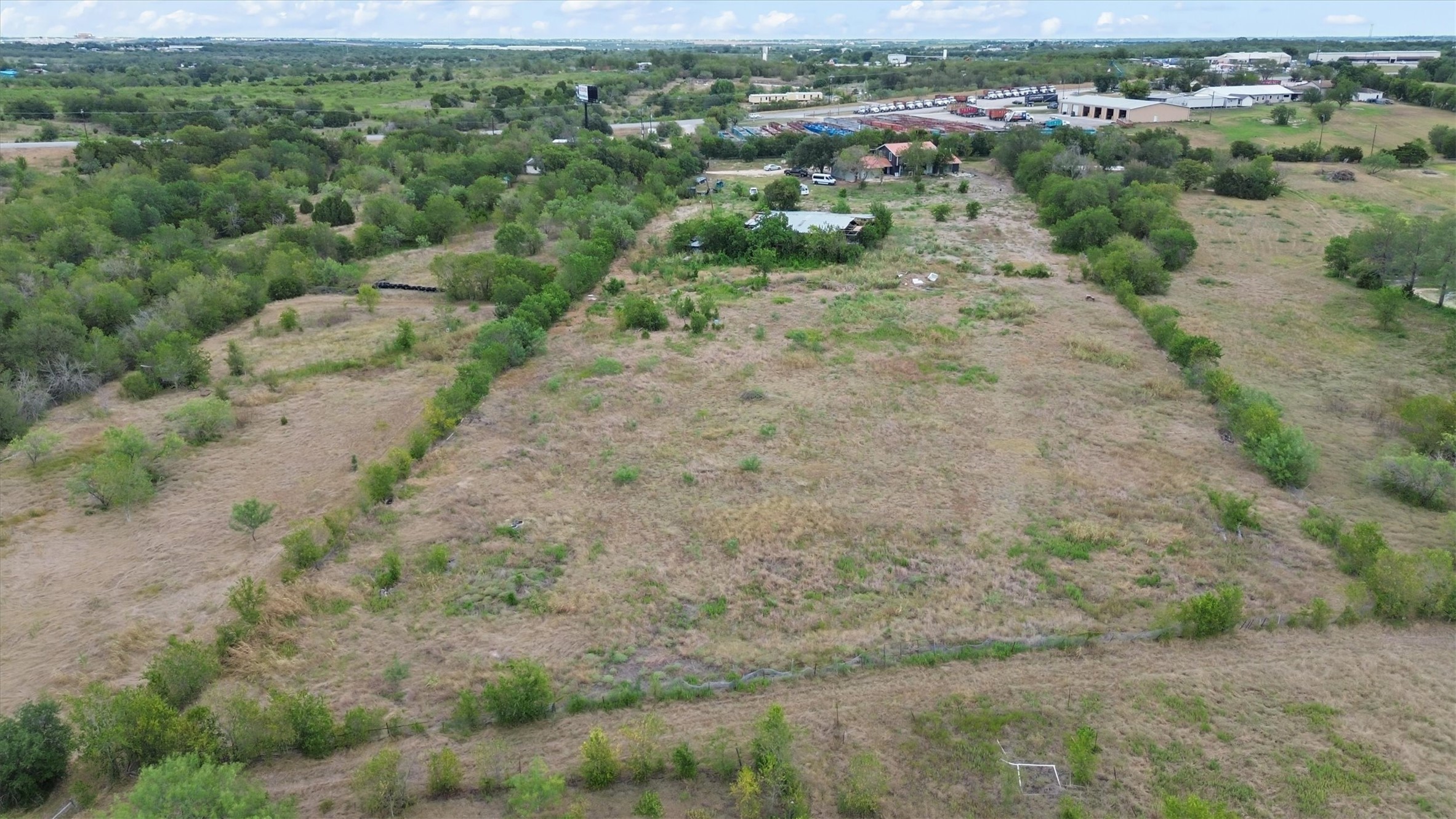 9100 Highway 183 Austin, TX 78747 - Photo 29 of 38 Mature trees outline the boundaries of a large, grassy acreage offering ample development potential.