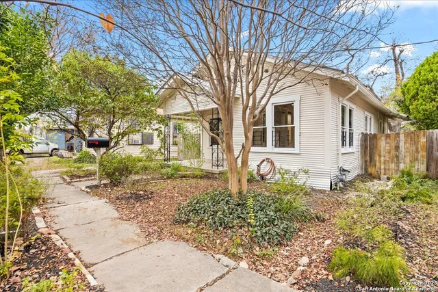 a backyard of a house with large trees and barbeque oven