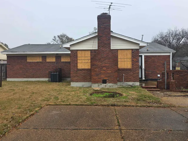 a view of a backyard with brick wall and a chair