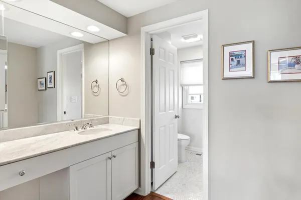 a bathroom with a granite countertop toilet and a shower