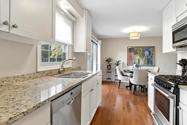 a kitchen with granite countertop stainless steel appliances a stove sink and microwave