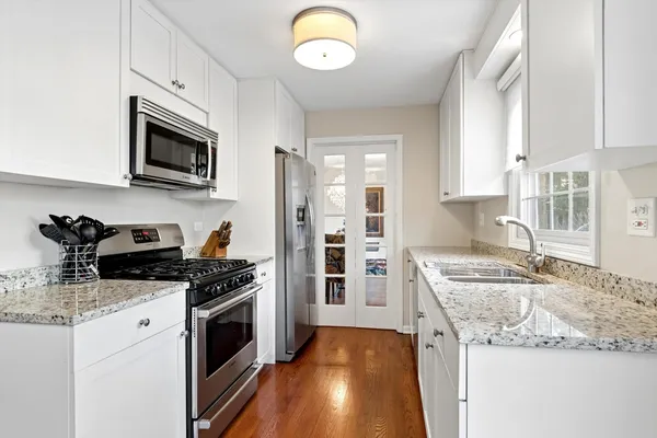 a dining room with furniture a large window and wooden floor