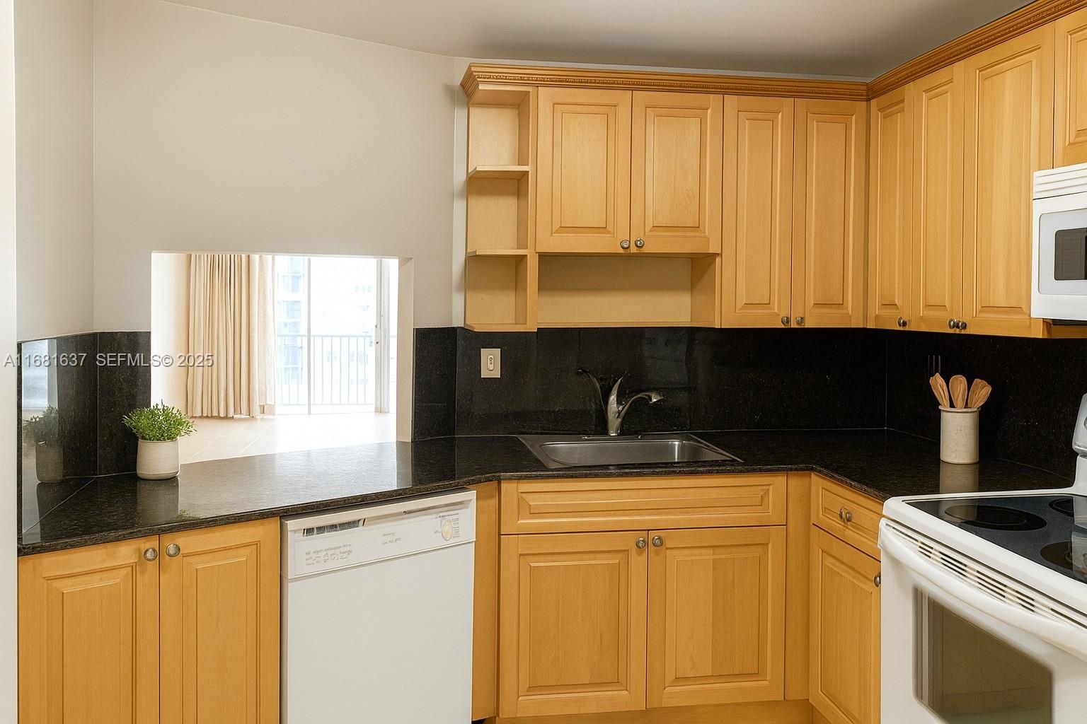 1750 Northeast 191st Street, Unit 8163 Miami, FL 33179 - Photo 4 of 7 a kitchen with granite countertop white cabinets and black appliances