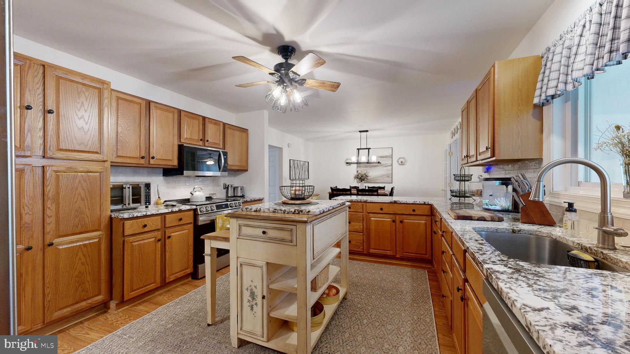 705 Deer Track Lane Dover, DE 19904 - Photo 12 of 29 a kitchen with granite countertop a sink a counter top space appliances and cabinets