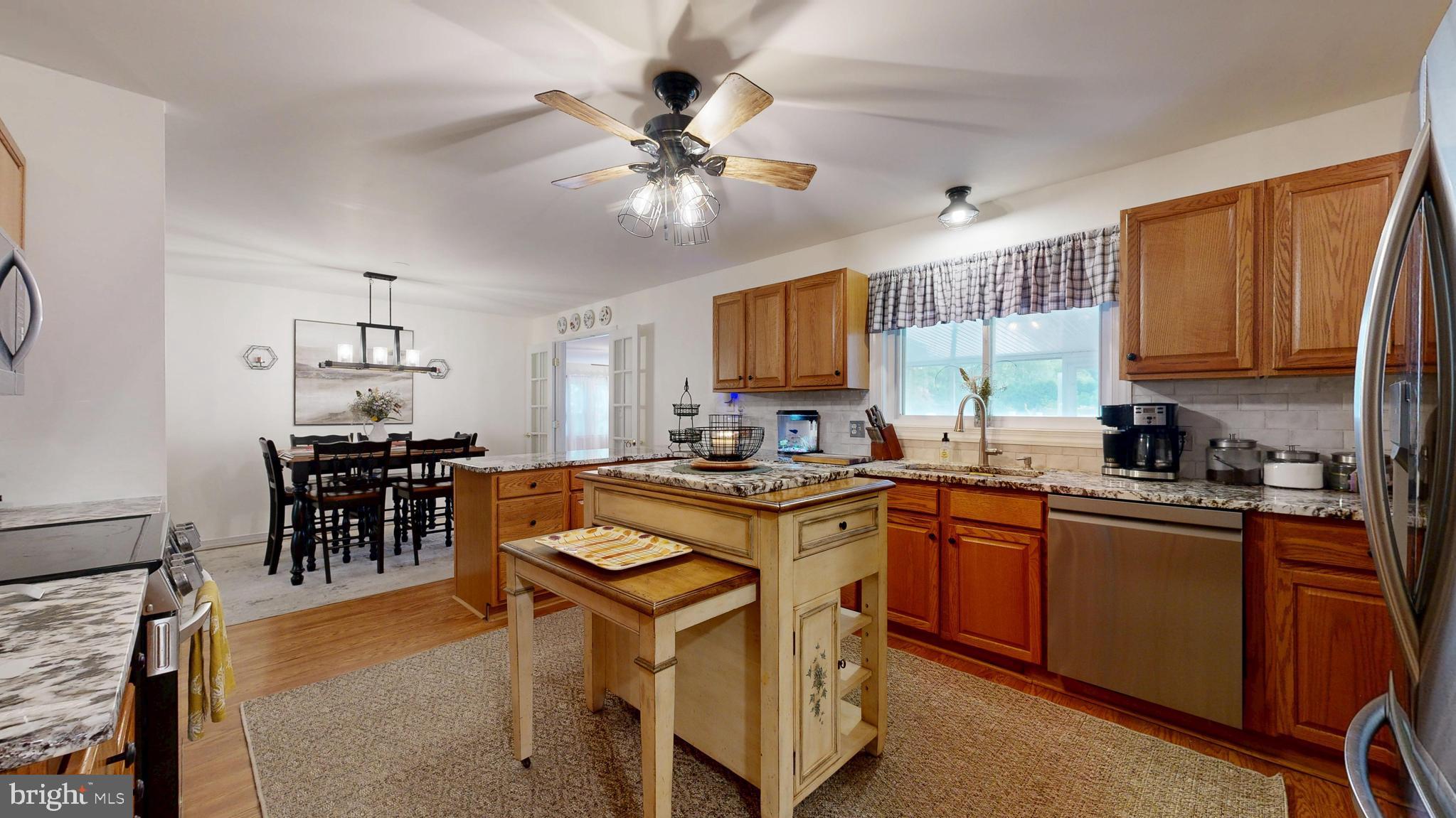 705 Deer Track Lane Dover, DE 19904 - Photo 13 of 29 a kitchen with stainless steel appliances granite countertop wooden cabinets a dining table and chairs