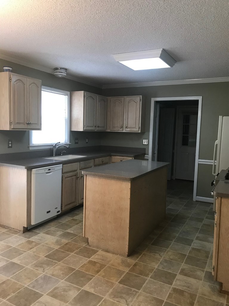 5931 Huddersfield Road Macon, GA 31210 - Photo 11 of 28 a kitchen with granite countertop a sink a counter top space and cabinets