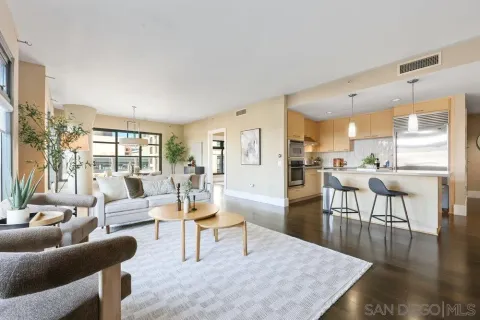 a living room with furniture wooden floor and a view of kitchen