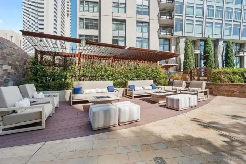 a roof deck view with a table and chairs and potted plants