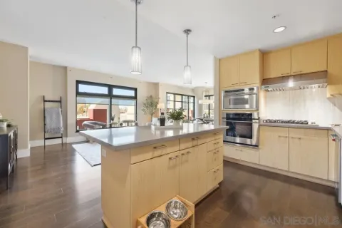 a kitchen with stainless steel appliances granite countertop a sink a stove and refrigerator