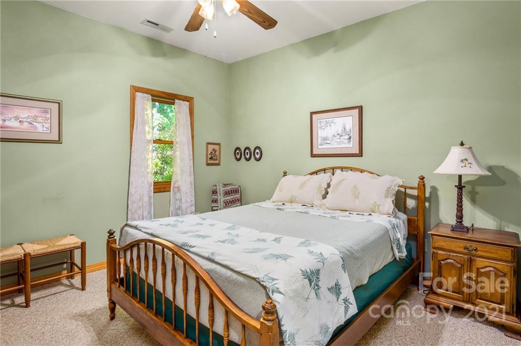 74 Apgar Road Candler, NC 28715 - Photo 21 of 46 a bedroom with a bed and a chandelier