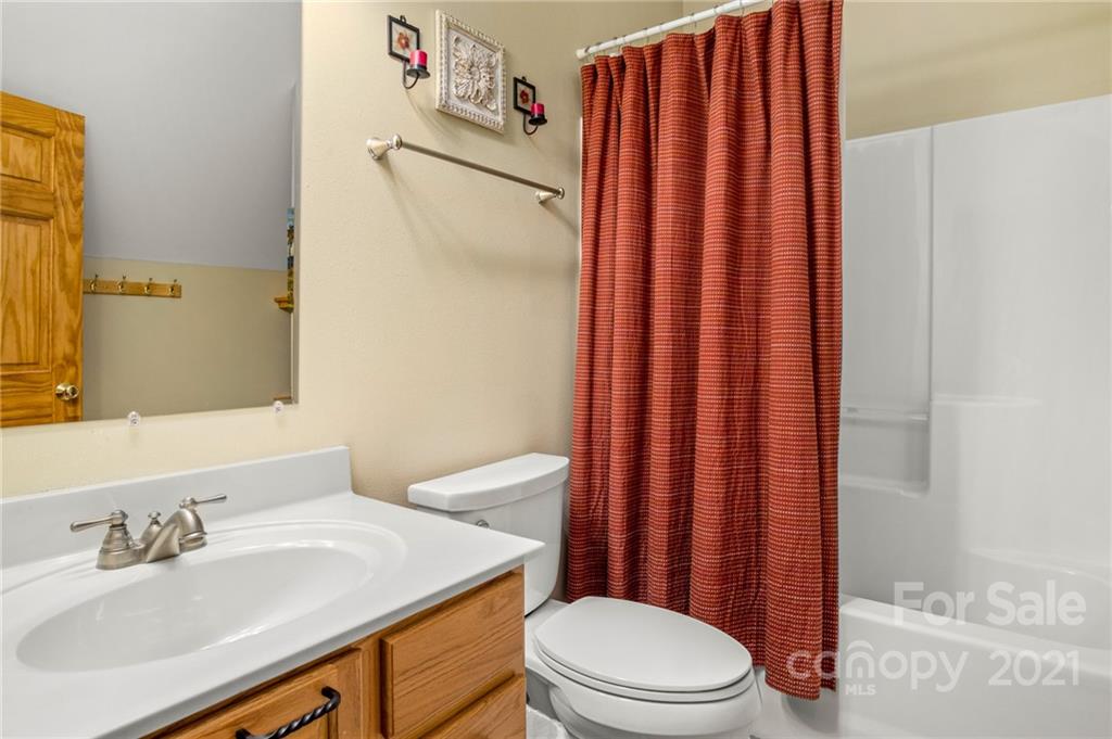 74 Apgar Road Candler, NC 28715 - Photo 23 of 46 a bathroom with a sink a toilet and shower curtain