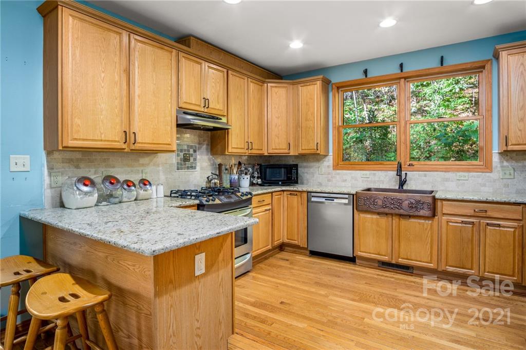 74 Apgar Road Candler, NC 28715 - Photo 7 of 46 a kitchen with stainless steel appliances granite countertop sink stove top oven and cabinets