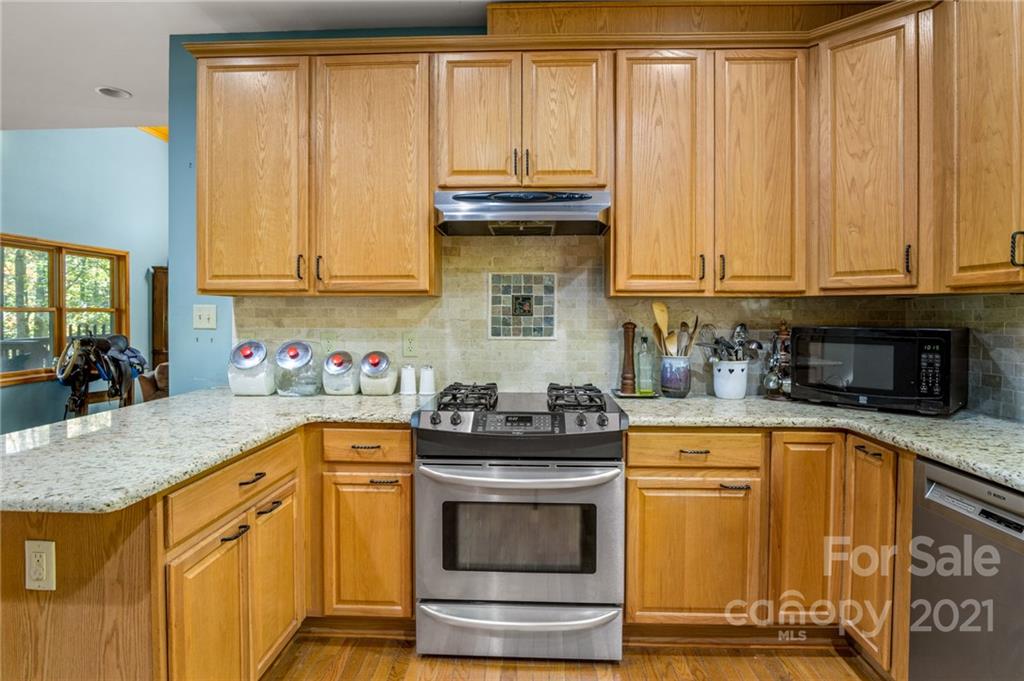 74 Apgar Road Candler, NC 28715 - Photo 8 of 46 a kitchen with granite countertop a sink a stove and cabinets