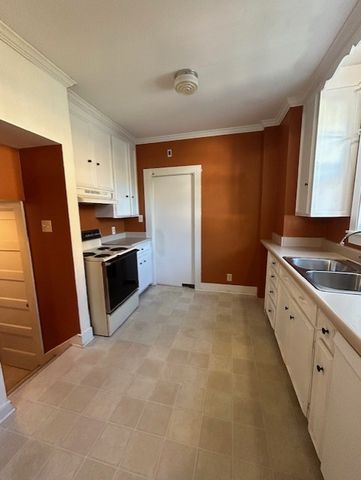 en empty room with windows and chandelier fan