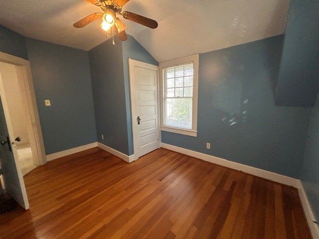 a bathroom with a tub a sink and wooden floor