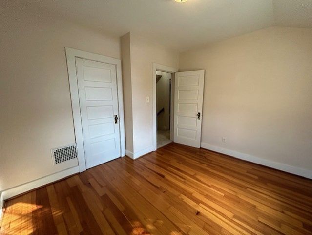 a view of an empty room with wooden floor