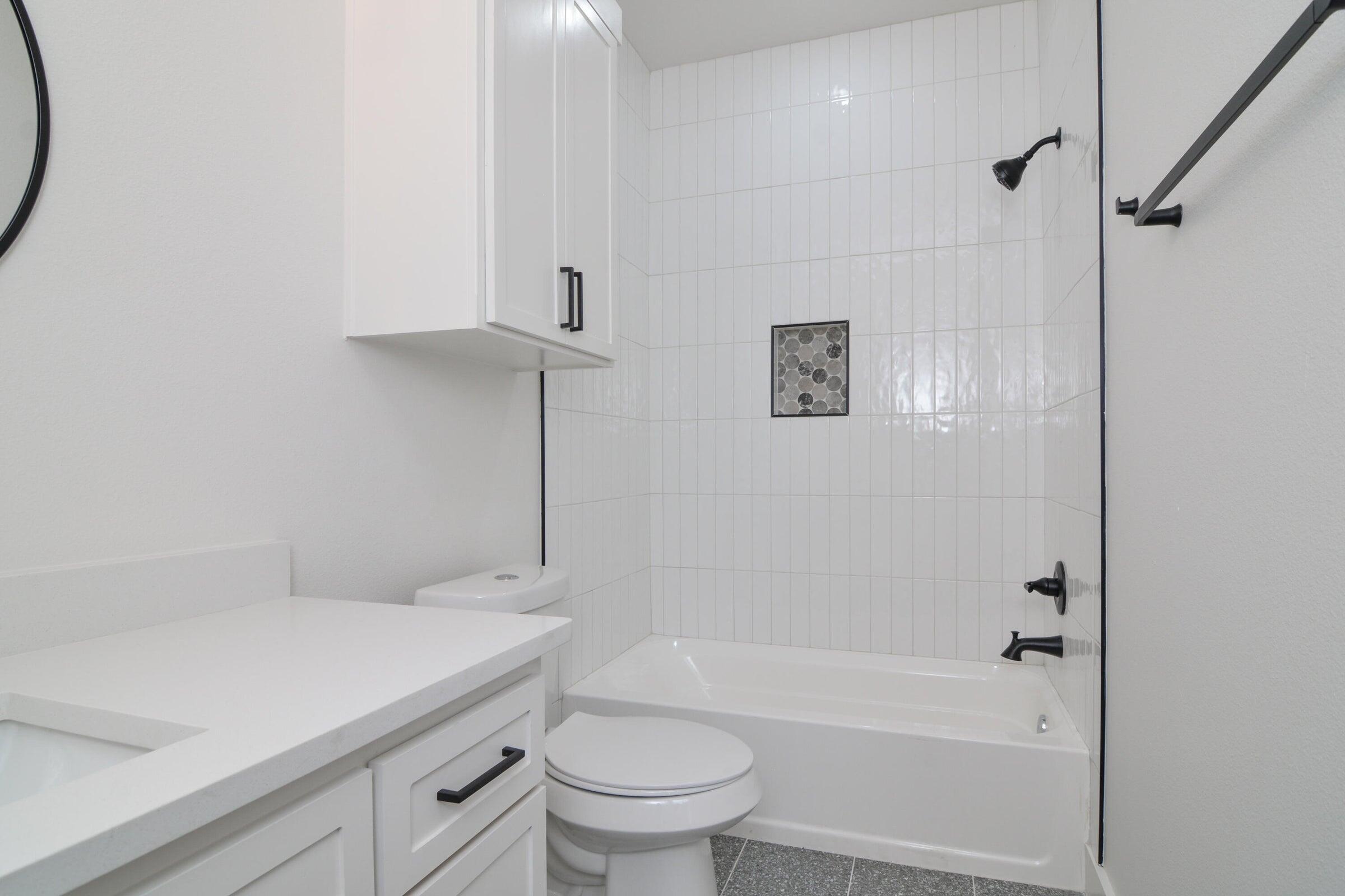 7801 56th Street Lubbock, TX 79407 - Photo 21 of 29 a bathroom with a sink a toilet and a bathtub