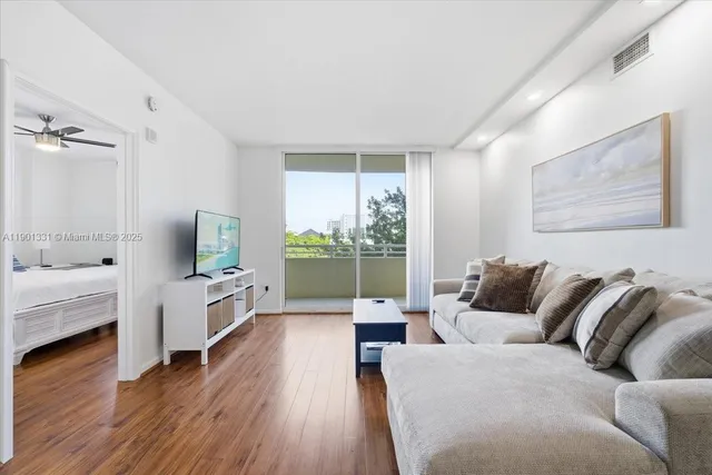 a living room with furniture and wooden floor