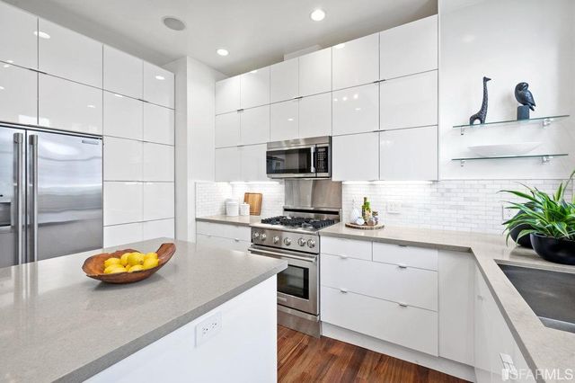 a kitchen that has a sink a stove and a wooden floor
