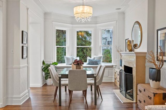 a view of a dining room with furniture a fireplace and wooden floor