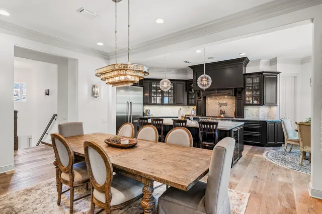 a view of a dining room and livingroom with furniture wooden floor a chandelier