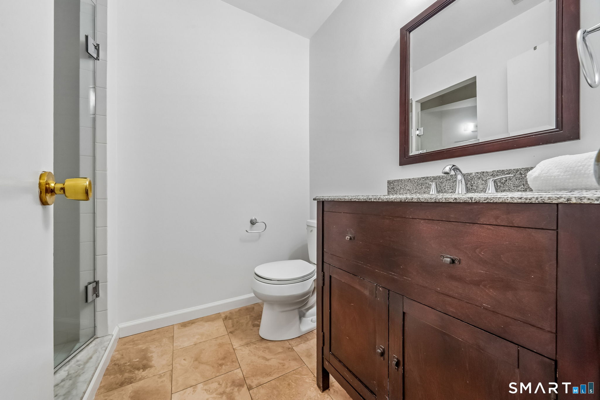 14 Ferris Avenue, Unit 9 Norwalk, CT 06854 - Photo 8 of 20 a bathroom with a granite countertop toilet sink and mirror