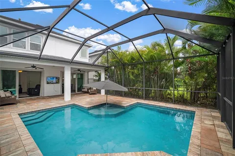 a kitchen with stainless steel appliances kitchen island granite countertop a dining table chairs refrigerator and microwave