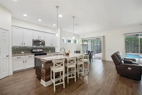 a kitchen with granite countertop a stove a sink and a microwave