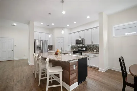 a kitchen with stainless steel appliances granite countertop a sink refrigerator and cabinets