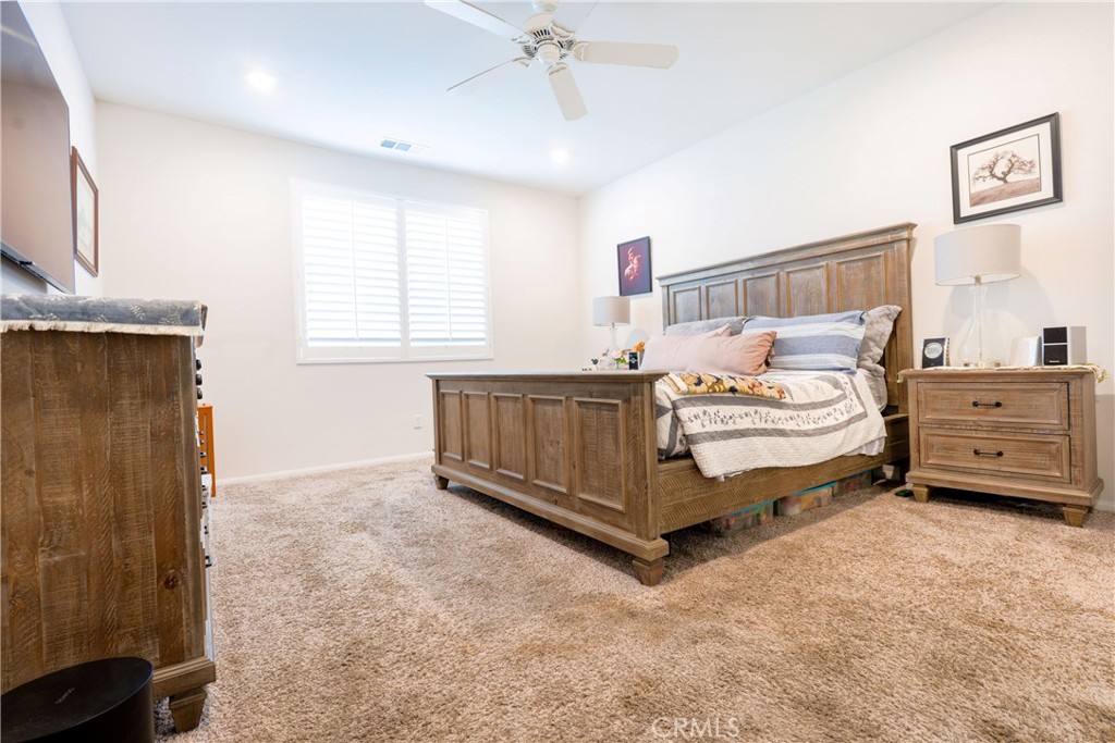 15630 Raptor Road Moreno Valley, CA 92551 - Photo 19 of 25 a spacious bedroom with a bed and a dresser