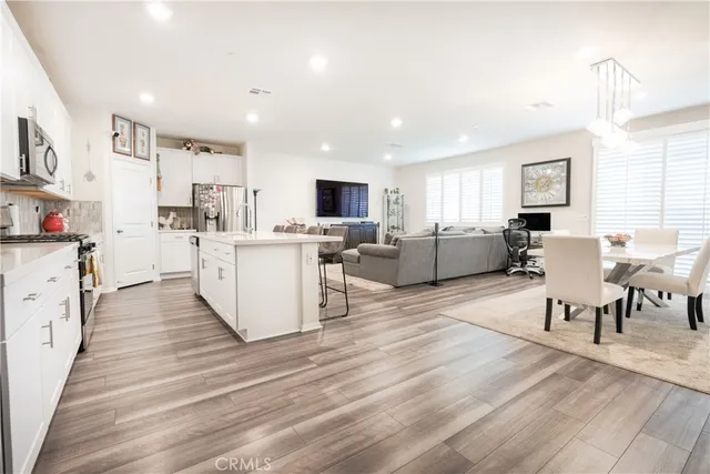 a large kitchen with stainless steel appliances lots of counter space and wooden floor